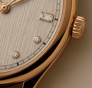 Macro of a rose-gold cushion-case watch with textured dial and applied markers